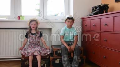 可爱的小女孩和男孩坐在老式手提箱上，等待开始度假。 小女孩穿<strong>花裙子</strong>